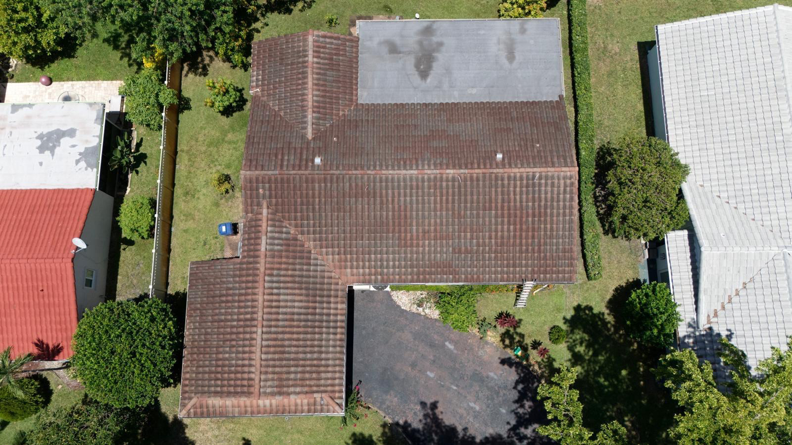 Barrel tile roof of a Pembroke Pines home covered in black algae streaks before roof cleaning